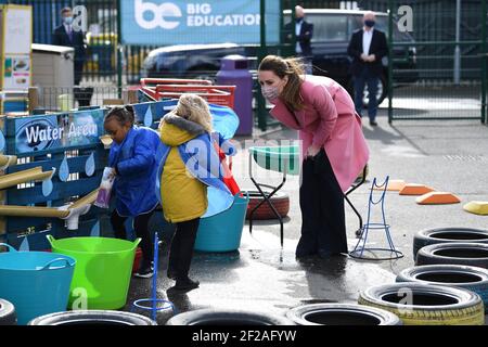 La Duchessa di Cambridge parla con un bambino nell'area dell'acqua del parco giochi durante una visita alla Scuola 21 a Stratford, a est di Londra. La visita coincide con l'introduzione di risorse per scuole mentalmente sane per le scuole secondarie che mettono la salute mentale al centro del curriculum scolastico. Data immagine: Giovedì 11 marzo 2021. Foto Stock