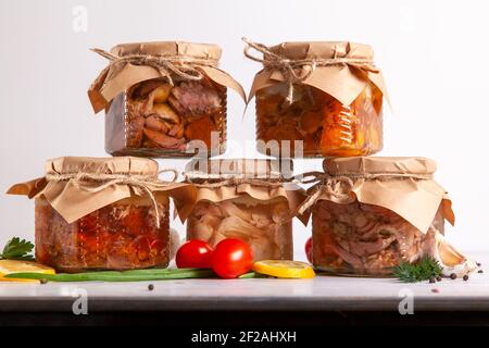 Carne casereccia fatta in casa da pollame-oca fattoria, anatra, pollo, maiale e manzo. Una piramide di lattine di vetro con cibo in scatola. Foto Stock