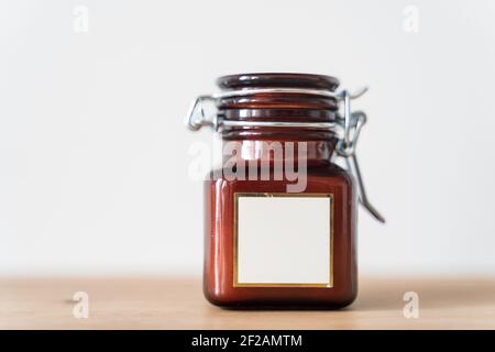 Candela profumata in un vaso di vetro su sfondo bianco. Vaso in vetro con candela aromatica. Foto di alta qualità Foto Stock