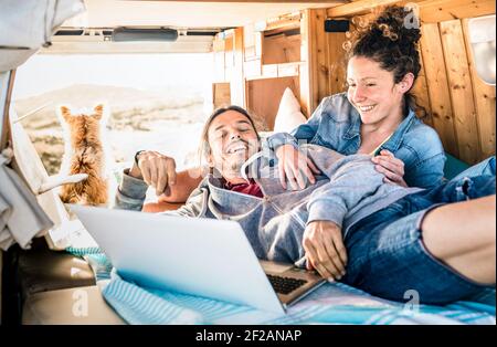 Coppia hipster con cane che viaggia insieme su mini van retrò Trasporti - concetto di ispirazione per la vita con persone indie su minivan avventura viaggio Foto Stock