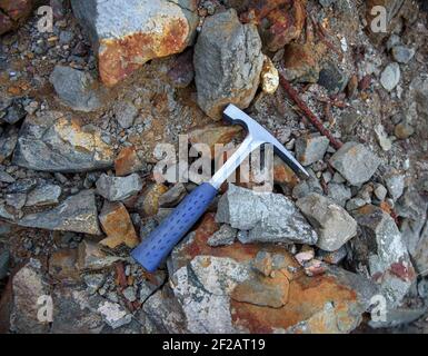 Scalpello in acciaio bordo picchio, geologo strumento su sfondo naturale rocce Foto Stock