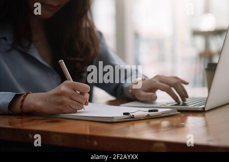 Closeup del braccio della mano della donna che scrive lavorando