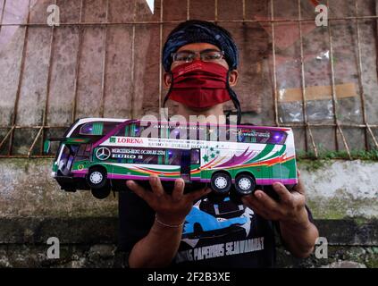 Bogor, Indonesia. 8 marzo 2021. Un uomo lavora per creare una replica in miniatura, 3D-stampato autobus papercraft indonesiano al suo laboratorio a Bogor, Indonesia l'8 marzo 2021. (Foto di Adrian Adi/INA Photo Agency/Sipa USA) Credit: Sipa USA/Alamy Live News Foto Stock