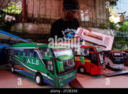 Bogor, Indonesia. 8 marzo 2021. Un uomo lavora per creare una replica in miniatura, 3D-stampato autobus papercraft indonesiano al suo laboratorio a Bogor, Indonesia l'8 marzo 2021. (Foto di Adrian Adi/INA Photo Agency/Sipa USA) Credit: Sipa USA/Alamy Live News Foto Stock