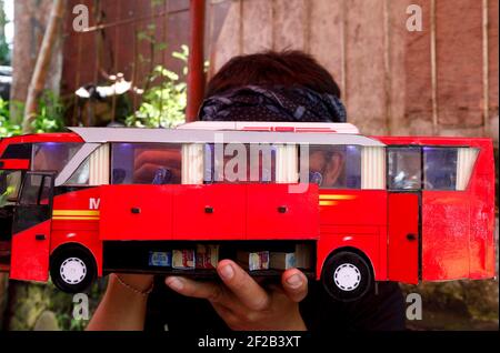 Bogor, Indonesia. 8 marzo 2021. Un uomo lavora per creare una replica in miniatura, 3D-stampato autobus papercraft indonesiano al suo laboratorio a Bogor, Indonesia l'8 marzo 2021. (Foto di Adrian Adi/INA Photo Agency/Sipa USA) Credit: Sipa USA/Alamy Live News Foto Stock