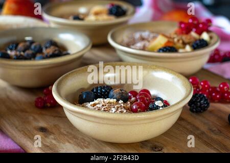 Diverse ciotole di oatmeals su un tavolo da cucina rustico con sfondo sfocato Foto Stock