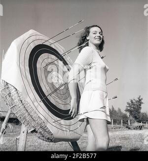 Tiro con l'arco negli anni '40. La giovane attrice svedese Mimi Nelson di fronte al bersaglio utilizzato quando si sparano le frecce. È vestita con il tipico jumper degli anni '40 e una gonna. Svezia 1947 Rif AD7-6 Foto Stock