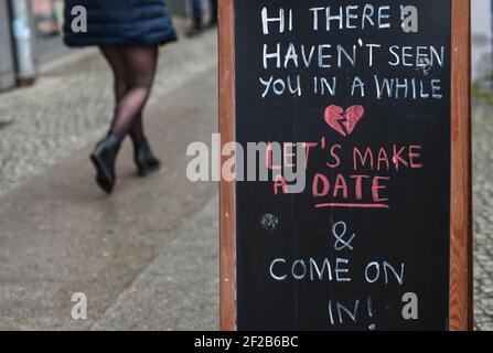 Berlino, Germania. 11 Marzo 2021. Di fronte a un negozio c'è un cartello che dice 'Ciao là! Non ti ho visto da un po'. Facciamo una data e andiamo!'. Dal 09.03.2021, i primi clienti sono nuovamente autorizzati a fare acquisti nei negozi su appuntamento. Credit: Kira Hofmann/dpa-Zentralbild/dpa/Alamy Live News Foto Stock