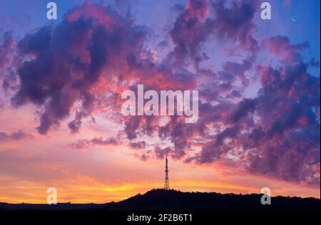 silhouette di torre di radiotelecomunicazione su cielo colorato nuvoloso mattina Foto Stock