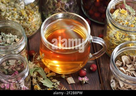 Tè alle erbe e vasetti con erbe aromatiche secche: Camomilla, tiglio, calendula, burdock, rosehips e fiori, closeup, copia spazio, naturopatia e natu Foto Stock