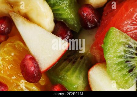 Primo piano dell'insalata di frutta a schermo intero, come sfondo. Fette di frutta fresca e sana per una dieta sana. Foto Stock