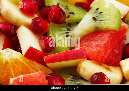 Primo piano dell'insalata di frutta a schermo intero, come sfondo. Fette di frutta fresca e sana per una dieta sana. Foto Stock
