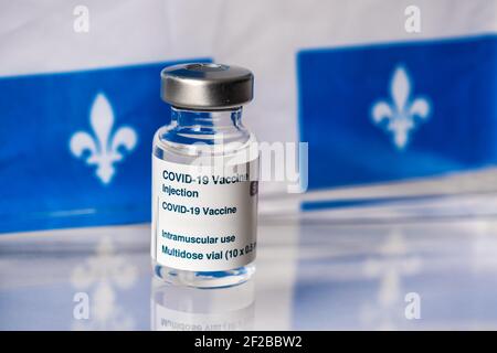 Flaconcino di vaccino Covid-19 davanti alla bandiera del Quebec Foto Stock