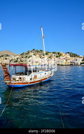 Tradizionale goletta in legno gita turistica in barca sulle acque dell'isola di Symi in Grecia Dodecanese. Foto Stock