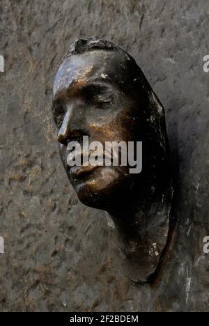 Jan Palach, studente ceco che si è messo in fiamme il 16 gennaio 1969 per protestare contro l'invasione sovietica della Cecoslovacchia nel 1968. Monumento commemorativo in bronzo su una parete esterna dell'Università Carlo, Praga, Repubblica Ceca. Lo scultore Olbram Zoubek (1926 - 2017) creò il volto nel 1990, da una maschera di morte presa in segreto poco dopo Palach autoimmolata nella vicina Piazza Venceslao. Il memoriale si trova in uno spazio pubblico conosciuto in epoca comunista come Piazza dei soldati dell'Armata Rossa e rinominata Piazza Jan Palach (Námestí Jana Palacha) dopo la Rivoluzione di velluto del 1989 in Cecoslovacchia. Foto Stock