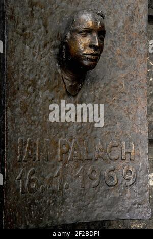 Jan Palach, studente ceco che si è messo in fiamme il 16 gennaio 1969 per protestare contro l'invasione sovietica della Cecoslovacchia nel 1968. Monumento commemorativo in bronzo su una parete esterna dell'Università Carlo, Praga, Repubblica Ceca. Lo scultore Olbram Zoubek (1926 - 2017) creò il volto nel 1990, da una maschera di morte presa in segreto poco dopo Palach autoimmolata nella vicina Piazza Venceslao. Il memoriale si trova in uno spazio pubblico conosciuto in epoca comunista come Piazza dei soldati dell'Armata Rossa e rinominata Piazza Jan Palach (Námestí Jana Palacha) dopo la Rivoluzione di velluto del 1989 in Cecoslovacchia. Foto Stock