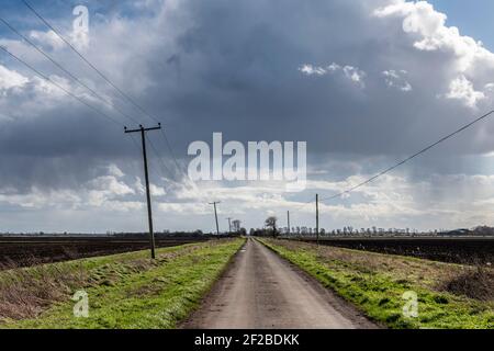 Haddenham Cambridgeshire, Regno Unito. 11 Marzo 2021. Il forte vento soffia un mix di sole e docce con spettacolari formazioni di nuvole nel grande cielo dell'Anglia Orientale sui pianeggianti paesaggi agricoli della Fenland. Il tempo del Regno Unito è previsto per continuare con le docce arrugginite nei prossimi due giorni. Credit: Julian Eales/Alamy Live News Foto Stock