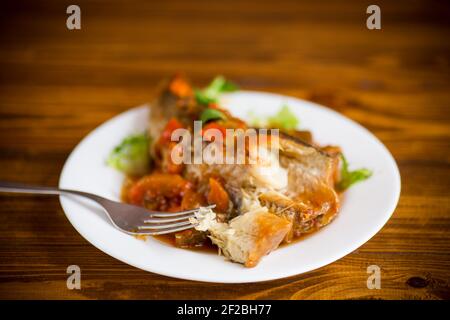 nasello intero stufato con carote, barbabietole, peperoni e altre verdure. Foto Stock