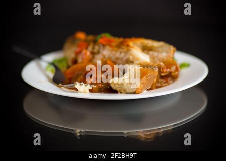 nasello intero stufato con carote, barbabietole, peperoni e altre verdure. Foto Stock