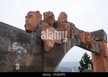 STEPANAKERT, NAGORNO KARABAKH - NOVEMBRE 05: Volti dall'aspetto antico scolpiti in pietra vulcanica decorano il memoriale di guerra dell'epoca sovietica costruito in onore dei 22,000 abitanti di Karabagh, morto durante la seconda guerra mondiale, collocato nel cimitero militare di Stepanakert, la capitale de facto dell'autoproclamata Repubblica di Artsakh o Nagorno-Karabakh, uno stato di spasso nel Caucaso meridionale Sostenuto dall'Armenia, il cui territorio è riconosciuto a livello internazionale come parte dell'Azerbaigian Foto Stock