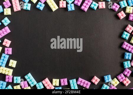 Telaio di blocchi di plastica giocattolo su sfondo nero Foto Stock