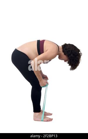 lateralmente di una donna incinta in piedi facendo bande di resistenza all'esercizio su sfondo bianco Foto Stock