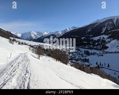 Villaggio montano innevato di munster nel vallese, i primi raggi di sole splende sulle montagne Foto Stock