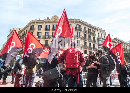 Barcellona, Spagna. 11 Marzo 2021. I manifestanti che detengono bandiere durante la manifestazione hanno manifestato circa 50 persone davanti alla delegazione del governo spagnolo a Barcellona contro la "precarietà dei subappaltatori" convocata da peli sintetici dei lavoratori, dalla Confederazione Generale del lavoro (CGT), dall'alternativa intersindacale della Catalogna (IAC) e dalla Confederazione Nazionale del lavoro (CNT). Credit: SOPA Images Limited/Alamy Live News Foto Stock