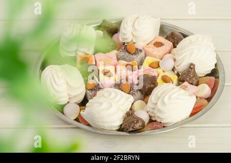 Vassoio con dolci sul tavolo - marshmallows, caramelle e delizia turca con fuoco selettivo Foto Stock