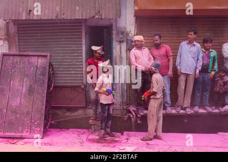 India, Mathura - i ragazzi spruzzano acqua colorata nella processione di Holi a Mathura. Foto Stock
