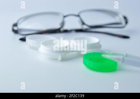 Contenitore per lenti a contatto e occhiali su sfondo grigio. Accessori per lenti a contatto. Concetto di pulizia regolare delle lenti. Focus selettivo sul caso. Foto Stock