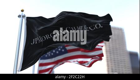 New York, USA, 28 gennaio 2021: Bandiera con il logo JPMorgan Chase & Co che svela nel vento con la bandiera americana sullo sfondo. JPMorgan Chase & Foto Stock