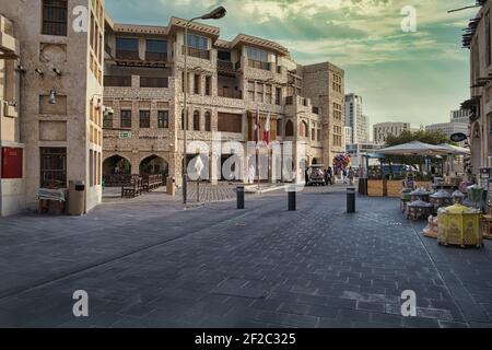 Souq waqif a Doha Qatar vista diurna che mostra la tradizionale architettura araba, bandiera del Qatar e le persone in strada Foto Stock