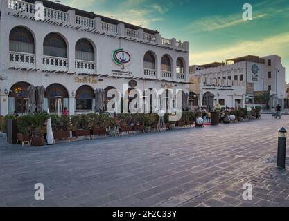 Souq waqif a Doha Qatar vista diurna che mostra la tradizionale architettura araba, caffè e le persone in strada Foto Stock