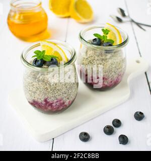 Chia pudding con mirtilli, scorza di limone e foglie di menta. Foto Stock