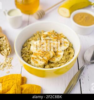 Farinata d'avena con burro di arachidi, banane e semi di chia. Foto Stock