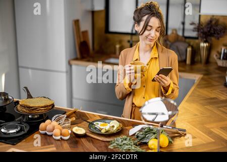 Giovane donna d'affari, troppo giovane, ha fretta di lavorare al mattino, bere caffè e usare il telefono in viaggio Foto Stock