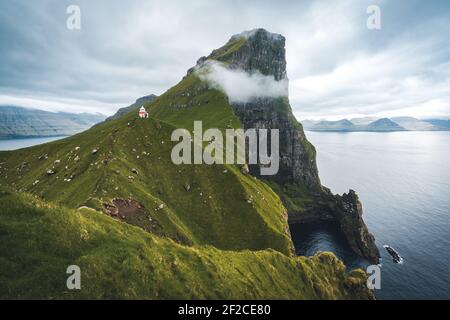 Isola di Kalsoy con il faro di Kallur sulle isole Faroe, Danimarca, Europa. Nuvole su alte scogliere, turchese oceano Atlantico e viste spettacolari. Foto Stock