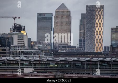 Skyline di Londra con grattacieli, tra cui Canary Wharf, in lontananza dalla stazione ferroviaria di Blackfriers nella città di Londra, in prima serata invernale. Foto Stock