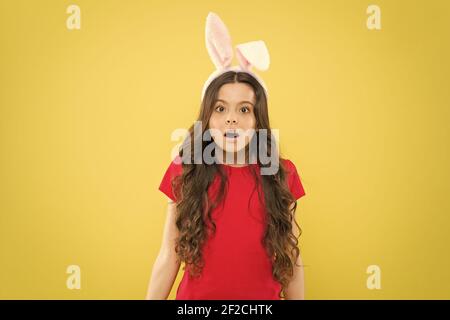 Sei pronto a festeggiare. Capretto sulla caccia all'uovo di Pasqua. Ragazzino in costume di coniglio che si divertono. buona pasqua. Bambina che indossa orecchie di coniglio. Sorpresa bambino in costume. Coniglio di Pasqua con orecchie. Foto Stock