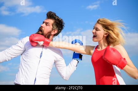 Relazioni come concetto di lotta. Uomo e donna lotta guanti di boxe sfondo cielo blu. Difenda la vostra opinione nel confronto. Relazioni e vita familiare Foto Stock