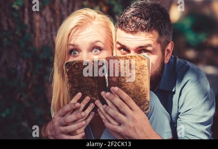 Coppia in amore leggere libro antico, sfondo scuro. Foto Stock