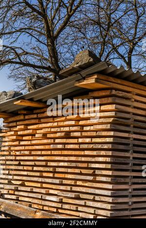 Legname e travi di legno. Catasta di legno di essiccazione ad aria. Essiccazione all'aria del legno. Legno per la costruzione di case. Materiale da costruzione. Magazzino di legno. Foto Stock