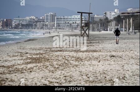 Palma, Spagna. 11 Marzo 2021. Un uomo cammina attraverso la sabbia sulla spiaggia di Arenal. I tour operator tedeschi sperano di poter riportare i turisti a Maiorca dalle vacanze di Pasqua. Credit: Clara Margais/dpa - ATTENZIONE: I nomi dei tubi sono stati pixelati per motivi legali/dpa/Alamy Live News Foto Stock