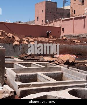 MARRAKECH, MAROCCO - 10 GIUGNO 2019: Operaio e tini per concia pelle in una delle antiche concerie di marrakech, morocco Foto Stock