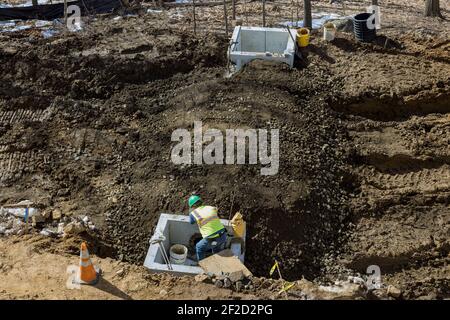 Costruzione installata di tubo di calcestruzzo di sistema di drenaggio su cui lavorare la strada per fognature di acqua drenata Foto Stock