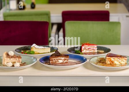 Assortimento di pezzi di torta sul tavolo, spazio copia. Diverse fette di deliziosi dessert, concetto di menu del ristorante. Foto Stock