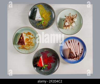 Assortimento di pezzi di torta sul tavolo, spazio copia. Diverse fette di deliziosi dessert, menu del ristorante, vista dall'alto. Foto Stock