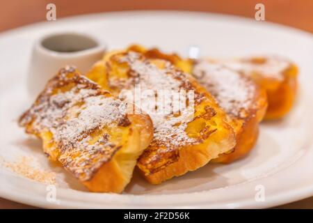 Primo piano sul piatto con toast francesi conosciuti anche come pane eggy fatto di pane affettato imbevuto in uova sbattute e latte poi padella fritti. Foto Stock