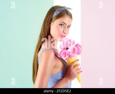 Bella ragazza in stile vintage. Donna retrò mangiare gelato da fiori. Fissa la donna con trucco alla moda. Bouquet di fiori. Estate ragazza. Bellissima Foto Stock